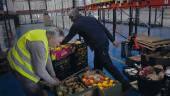 Dos voluntarios del Banco de Alimentos en Jaén distribuyen piezas de frutas junto a las estanterías. / F. Gaitán / Diario JAÉN. 
