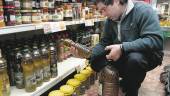OFERTA. Un consumidor compra aceite de oliva en el supermercado y mira sus cualidades en la etiqueta.