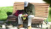 ACCIÓN. Una persona abre una bolsa de patatas sentado en un banco en uno de los parques de la capital. 