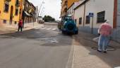 PREVENCIÓN. Varias personas desinfectan una calle on producto de la cuba de un tractor.