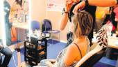 DE ARCHIVO. Un peluquero se afana en arreglar el cabello de una mujer.