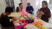 MANUALIDADES. Varias voluntarias de Ajicam elaboran pañuelos y pulseras, entre otros objetos.