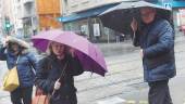 INTENSA LLUVIA. Dos mujeres y un hombre se protegen de la lluvia paraguas en mano en el Paseo de la Estación durante la jornada de ayer.