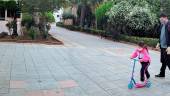 EN CAMBIL. Una niña, acompañada de su padre, se pasea con su juguete preferido junto a la iglesia de Nuestra Señora de la Encarnación el domingo. 