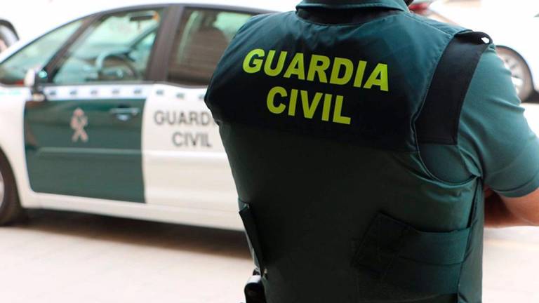 n agente de la Guardia Civil, de espaldas, junto a un vehículo oficial. / Guardia Civil / Archivo Europa Press. 