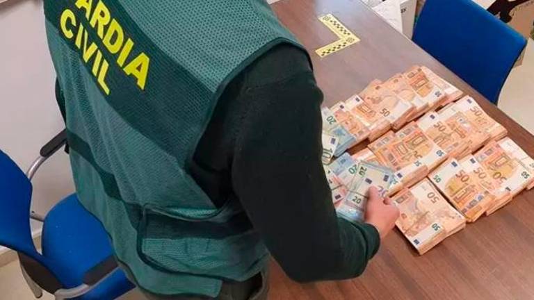 Agente cuenta el botín recuperado procedente del robo. / Guardia Civil. 