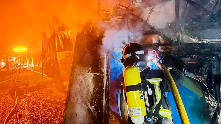 Así apagan los bomberos un autobús ardiendo en Cárcheles tras el desalojo de viajeros