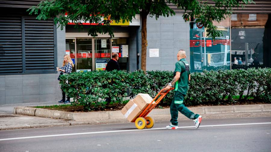 <i>Un repartidor y, al fondo, oficina de empleo. / Carlos Luján / Europa Press.</i> <i>Un repartidor y, al fondo, oficina de empleo. / Carlos Luján / Europa Press.</i>