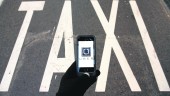 SUSTITUTO. Un móvil con la aplicación de Uber abierta sobre la señal de carril para taxis de la carretera.