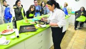 AOVE. Manuela Monsalve prepara un emplatado bajo la atenta mirada de los alumnos del taller de cocina.