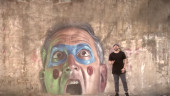 SECUENCIA. El cantante Sergio Tudela interpreta “Un paso al frente” ante uno de los retratos de Miguel Ángel Belinchón, “Belin”, en Linares.
