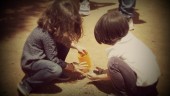 DIVERSIÓN. Dos niños juegan con la tierra sin preocuparse por lo que ocurre a su alrededor.