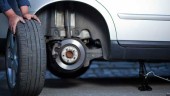 imagen. Un mecánico retira un neumático de un coche.