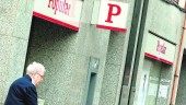 PASEO. Una persona mayor camina frente a una de las oficinas del Banco Popular en la capital.