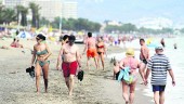 ARENA. Personas pasean por la playa para disfrutar de un día de verano junto a la costa.