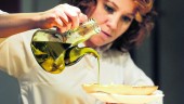 DIETA. Una mujer vierte aceite de oliva sobre una tostada.