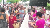 COCINA. Visitantes y locales se acercan a la mesa en la que la asociación de mujeres reparte el gazpacho de cereza. 
