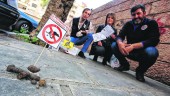 PROTESTA. José Luque, Antonia Ochando y Manuel Ruiz colocan los carteles en los excrementos de perro.