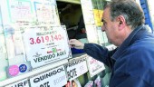 VETERANO. El lotero Miguel Ángel Hurtado muestra el cartel que informa de su premio millonario.