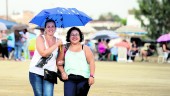 PRECIPITACIONES. Dos jóvenes pasean cogidas del brazo por las calles de Linares y se guarecen de la lluvia bajo un paraguas.