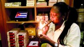 TABACO. Una mujer enciende un cigarro puro en una expendiduría de tabacos de La Habana. 