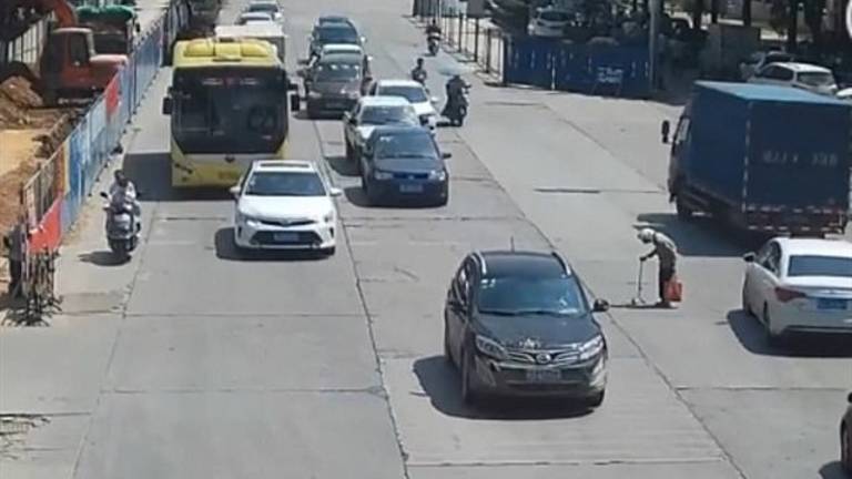 Un motorista detiene el tráfico para que una anciana cruce a salvo en China Un motorista detiene el tráfico para que una anciana cruce a salvo en China