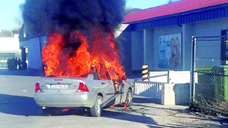 Incendio de un coche junto a una rotonda