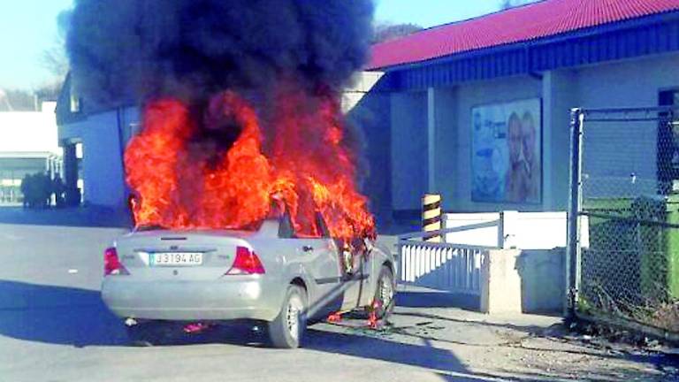 Incendio de un coche junto a una rotonda