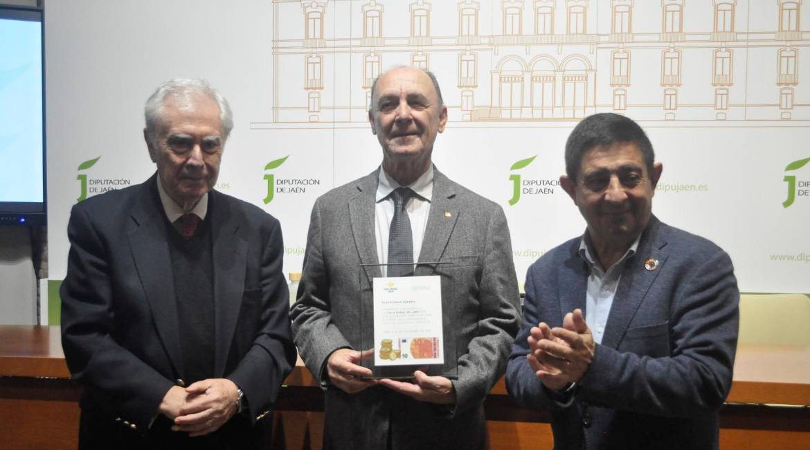 El presidente de Caja Rural de Jaén, Juan Núñez, sostiene una placa de reconocimiento flanqueado por su homólogo de Denaria, Javier Rupérez; y el de la Diputación Provincial de Jaén, Francisco Reyes. / F. Gaitán / Diario JAÉN.