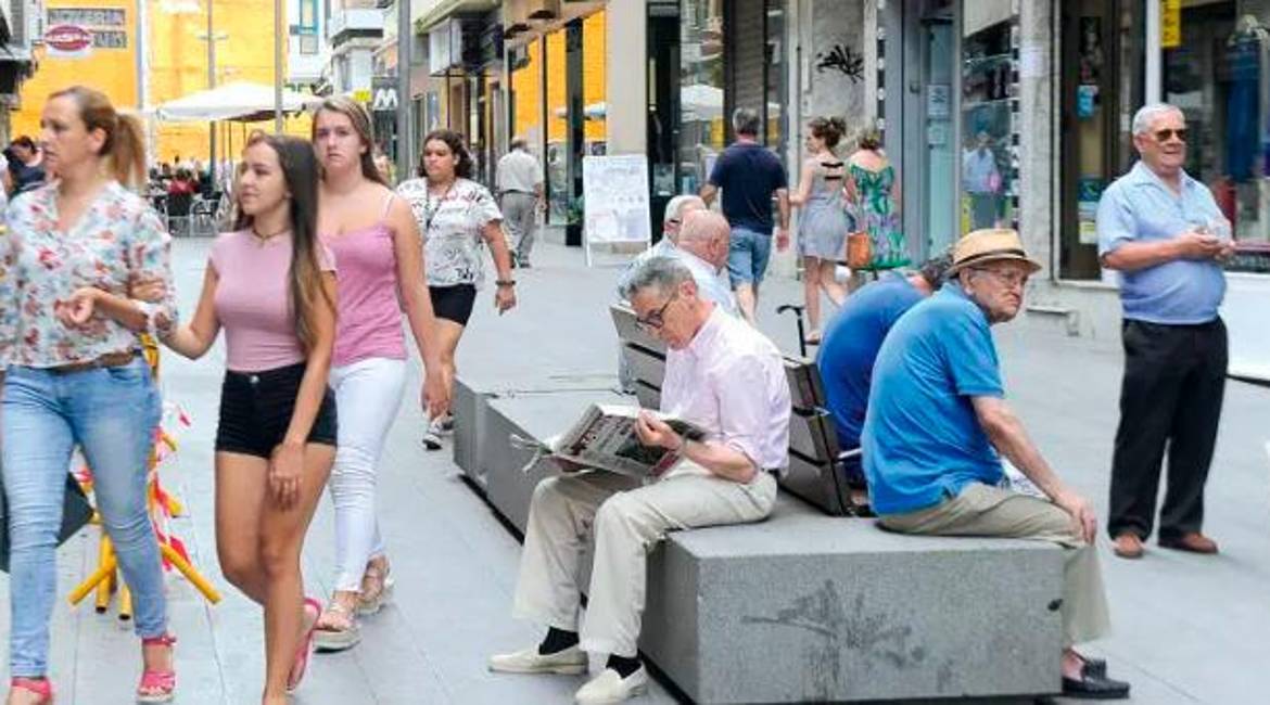 Diferentes personas caminan por la calle San Clemente junto a un grupo de mayores, sentados en uno de los bancos. / Agustín Muñoz / Diario JAÉN. 
