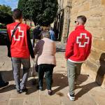 Imagen de archivo de voluntarios acompañando a una mujer mayor durante un paseo. / Cruz Roja.