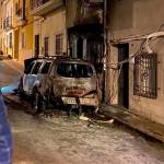 El coche abrasado por las llamas tras la actuación de los equipos de emergencia a las puertas de la fachada del domicilio de Joaquín Requena.