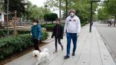 GRANADA. Dos niños con mascarillas acompañados por su padre pasean al perro. 