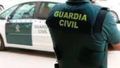 Un agente de la Guardia Civil, de espaldas, junto a un vehículo oficial. Archivo. / Guardia Civil.