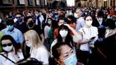 REPÚBLICA. Ciudadanos con mascarillas esperando a la pasada de un avión de la Fuerza Aérea italiana. 