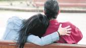 AMOR. Una pareja se da muestras de afecto en público en el banco de un parque.