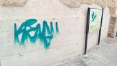 Pintadas sobre la muralla y un panel explicativo del monumento.