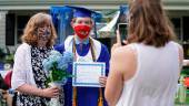 COVID-19. Daniel Cahill posa para una fotografía con su madre durante la ceremonia de su graduación honoraria de la covid-19 en el patio delantero de su casa. Se celebró para tres estudiantes de la Escuela Secundaria Bishop O’Connell en un hogar de Falls Church, en Virginia (Estados Unidos).