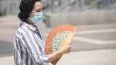 EN SEVILLA. Una mujer con mascarilla se abanica durante un episodio de altas temperaturas en la capital hispalense.