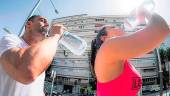 ARCHIVO. Dos personas beben agua mientras deporte en la capital. 