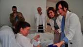Maribel Lozano entrega la moneda a Luisa Molina, madre de Pablo Carrasco, en el hospital Materno-infantil bajo la mirada de Trinidad Rus.