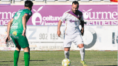 El recién renovado jugador del Real Jaén, Migue Montes, avanza con el balón ante un rival del Mancha Real.
