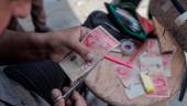 Un palestino arregla un billete desgastado, en el sur de la Franja de Gaza. / Rizek Abdeljawad / Europa Press.