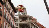 MADRID. Varios operarios colgados de una grúa trabajan en la inspección ocular del edificio tras la explosión.
