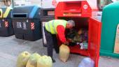 Un trabajador de Recuperaciones Redoble recoge ropa de un contenedor en Jaén. / Cáritas Jaén.