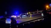 ATROPELLO. Agentes de la Policía Local, junto al cadáver, que yacía en la autovía.