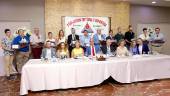 FOTO DE FAMILIA. Lo galardonados, de pie con sus trofeos, y las autoridades, sentados a la mesa, durante la Gala Amigos del Deporte, celebrada en Bailén.