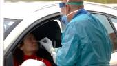 PREVENCIÓN. Un sanitario le hace la prueba para diagnosticar la infección por coronavirus a una mujer desde su vehículo.