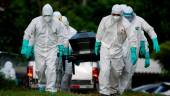 MUERTES. Los trabajadores del cementerio llevan el ataúd de un fallecido por coronavirus en el cementerio Cementerio Jardín en Soyapango, en El Salvador.