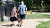 Un hombre acompaña a una mujer mayor durante un paseo a mediodía por el parque del barrio del Bulevar. / Jason Moyano / Diario JAÉN. 